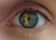 Primerísimo plano de un ojo que tiene en el iris el rostro de Mockus